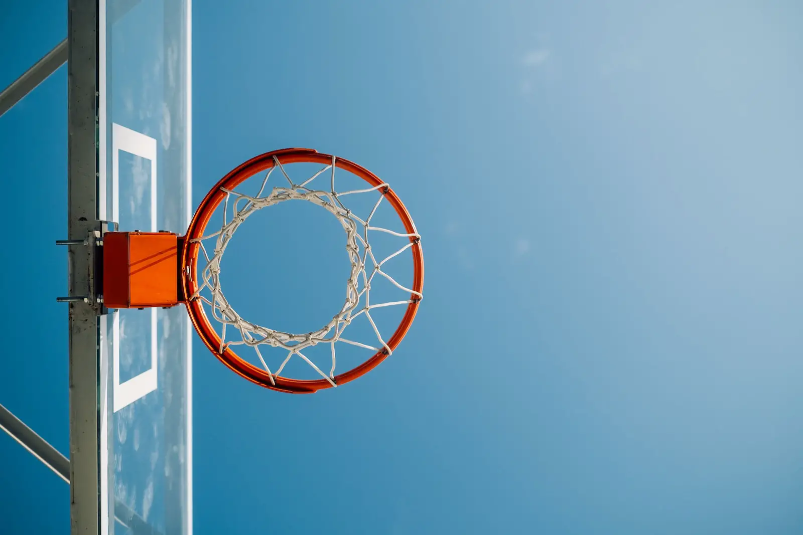 white and orange basketball hoop under blue sky during daytime