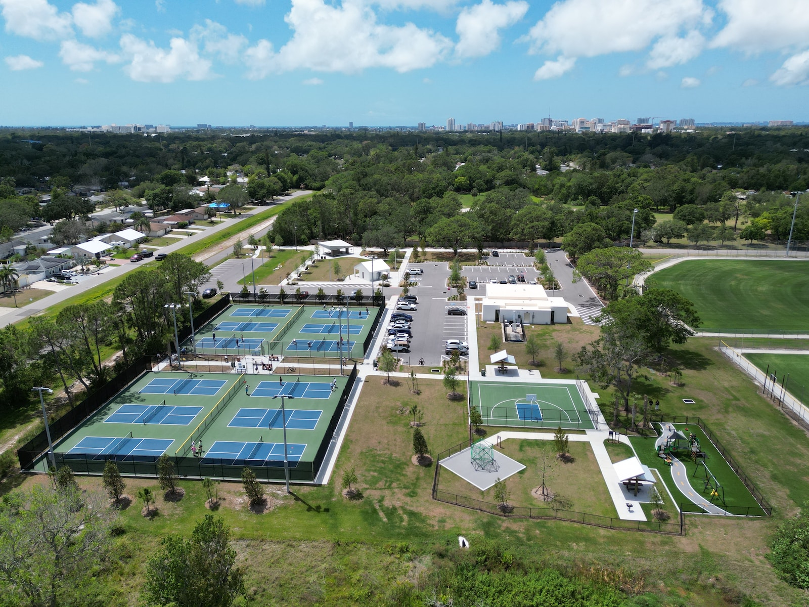 an aerial view of a tennis court surrounded by trees